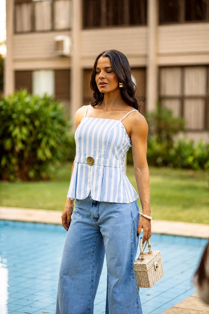 Blusa de alcinha listrada em azul e branco com fivela dourada, usada com jeans wide leg